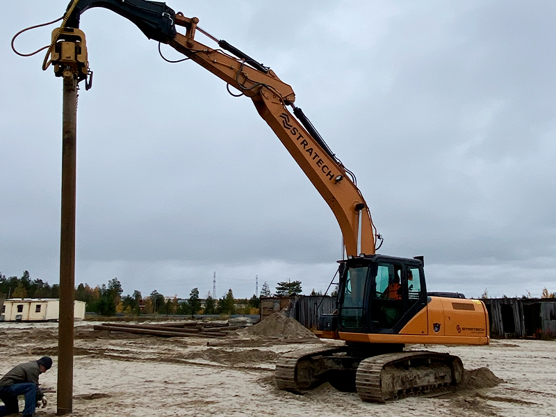 Вибропогружатель на строительной площадке, готовый к погружению трубы